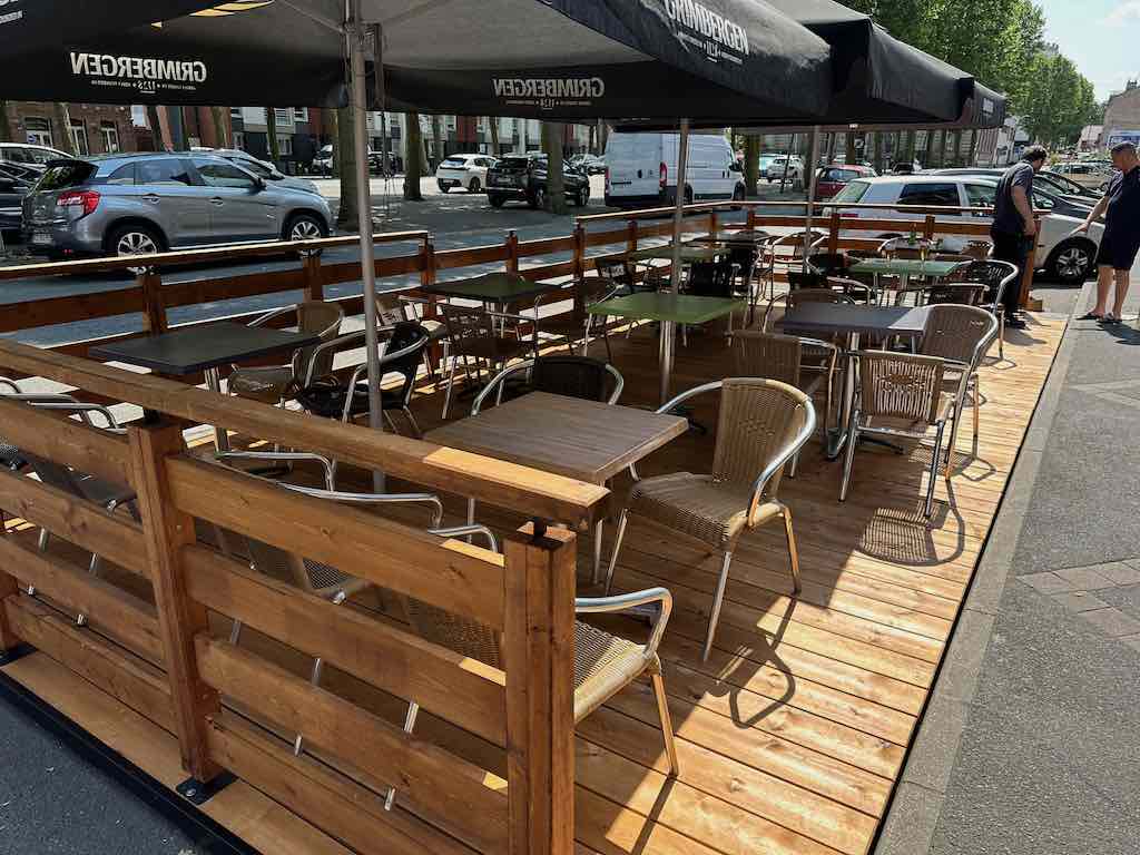 Terrasse en bois en cours d’installation avec des tables et chaises en osier et métal