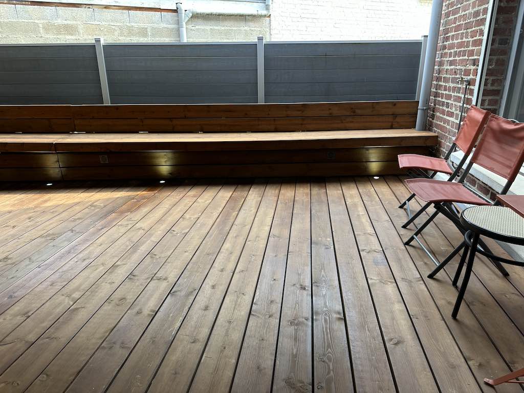 Banc en bois cachant des bacs à plantes, réalisé avec KitTerrasse Pro à Valenciennes.