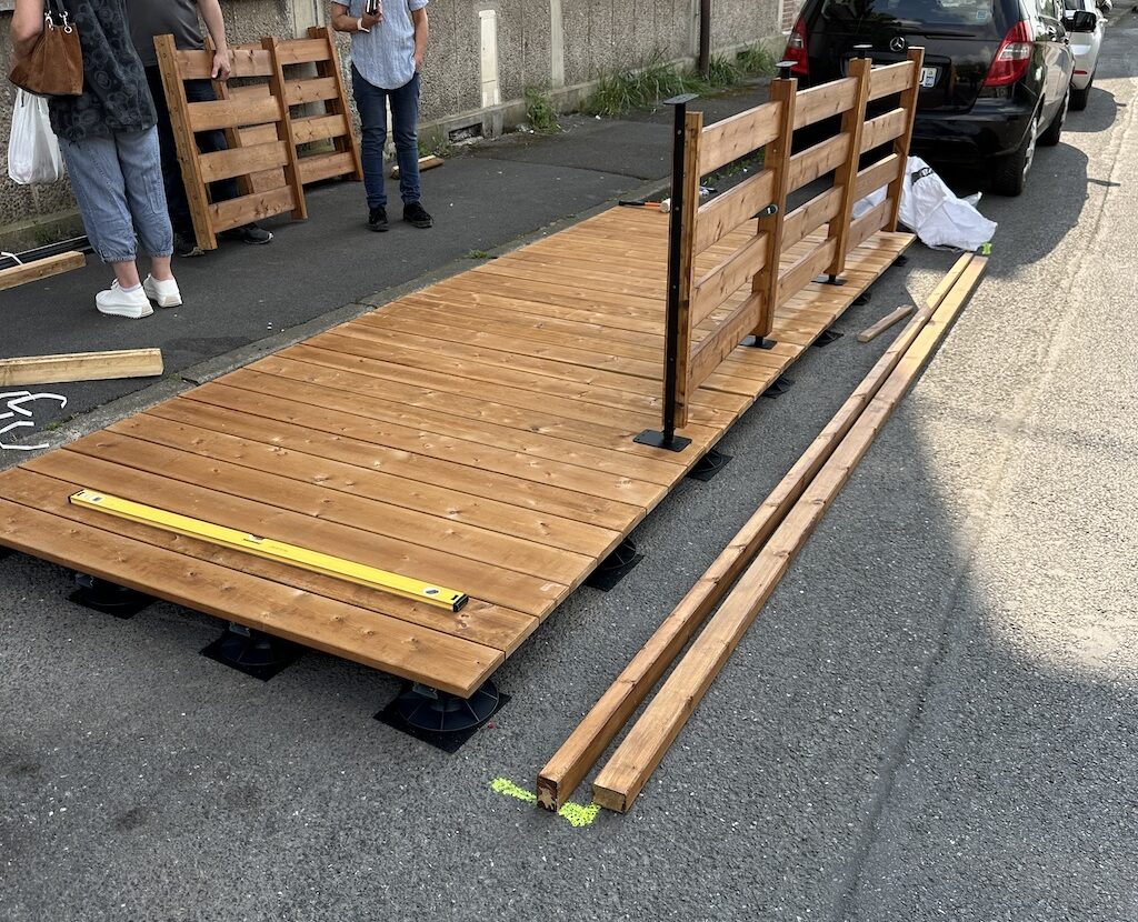 Installation en cours de la terrasse en bois au Corner de Charleville avec des travailleurs sur le site.