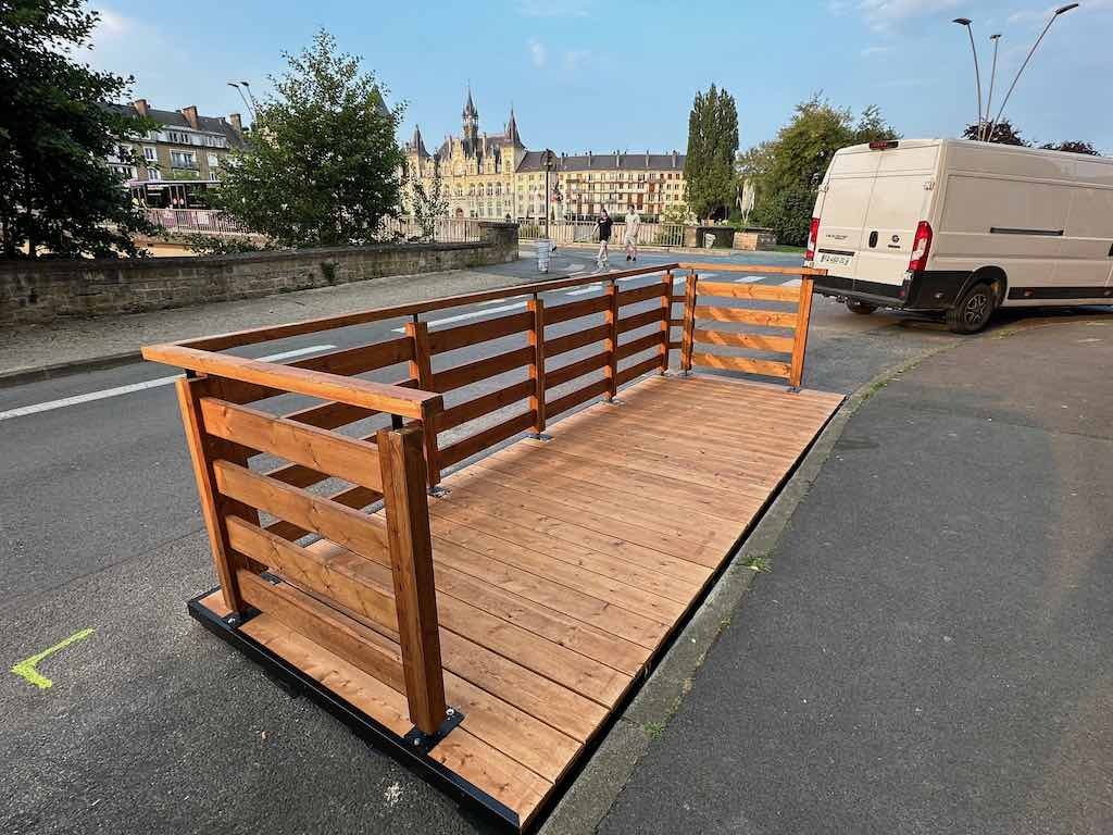 Terrasse bois en cours d’installation sur une rue, avec vue sur la mairie de Charleville